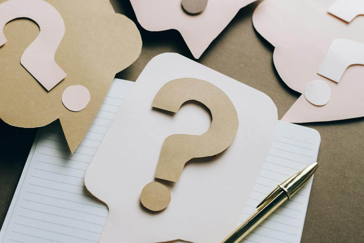 Question marks made of paper cut out to make a collage.