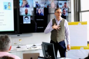 Pete Pachal stands in front of a room of people while training them on AI.